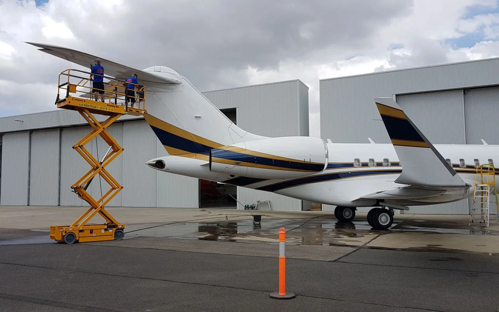 Jet Refined crew washing a business jet tail from a scissor lift
