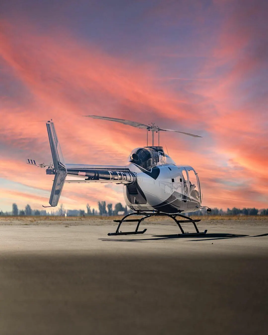 Detailed helicopter on the ramp beneath a dramatic sunset sky