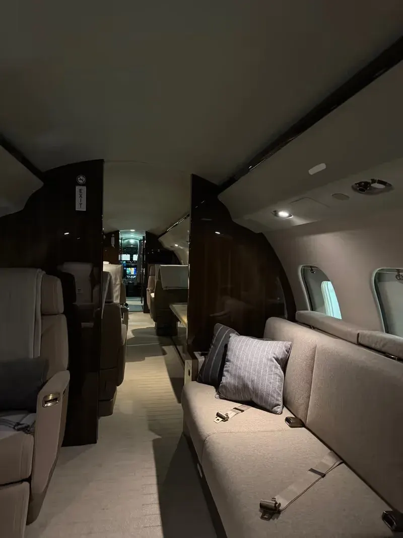 Light jet cabin with woodgrain veneer and cream leather divan