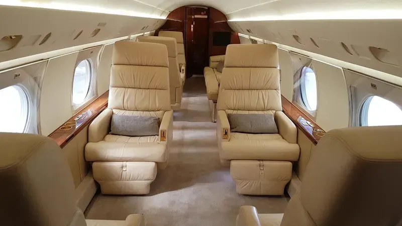 Large-cabin jet interior in tan leather with polished wood veneer