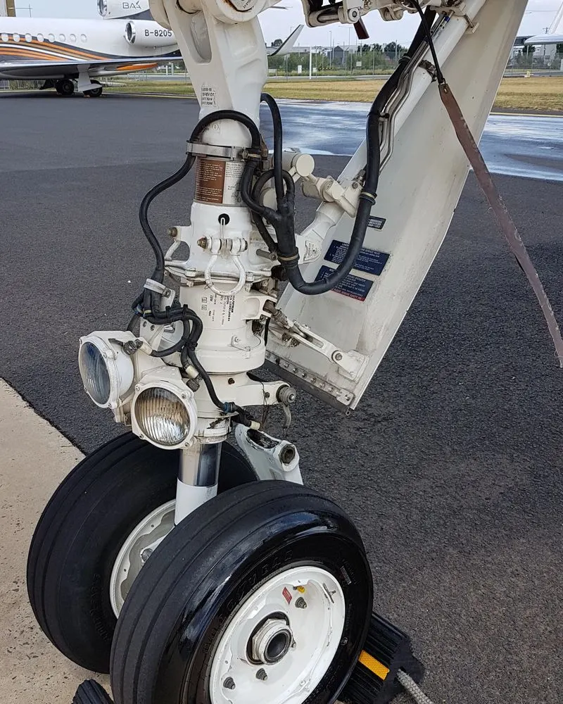 Nose gear leg and taxi light assembly cleaned to bare finish